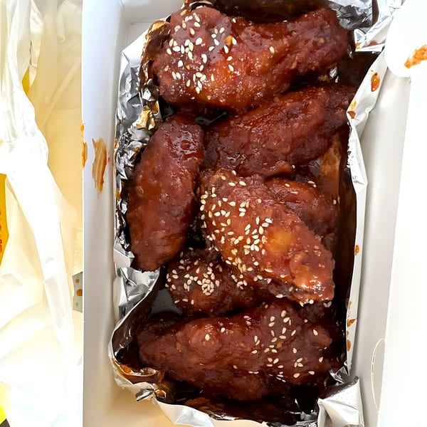 Noori Chicken's Korean fried chicken wings, glazed in a dark sauce and sprinkled with sesame seeds.